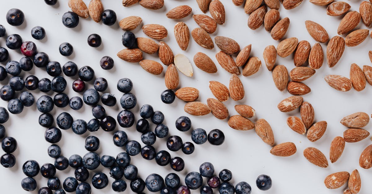 What natural ingredients can be used to color food blue or green? - Raw almonds and fresh blueberries put on white surface