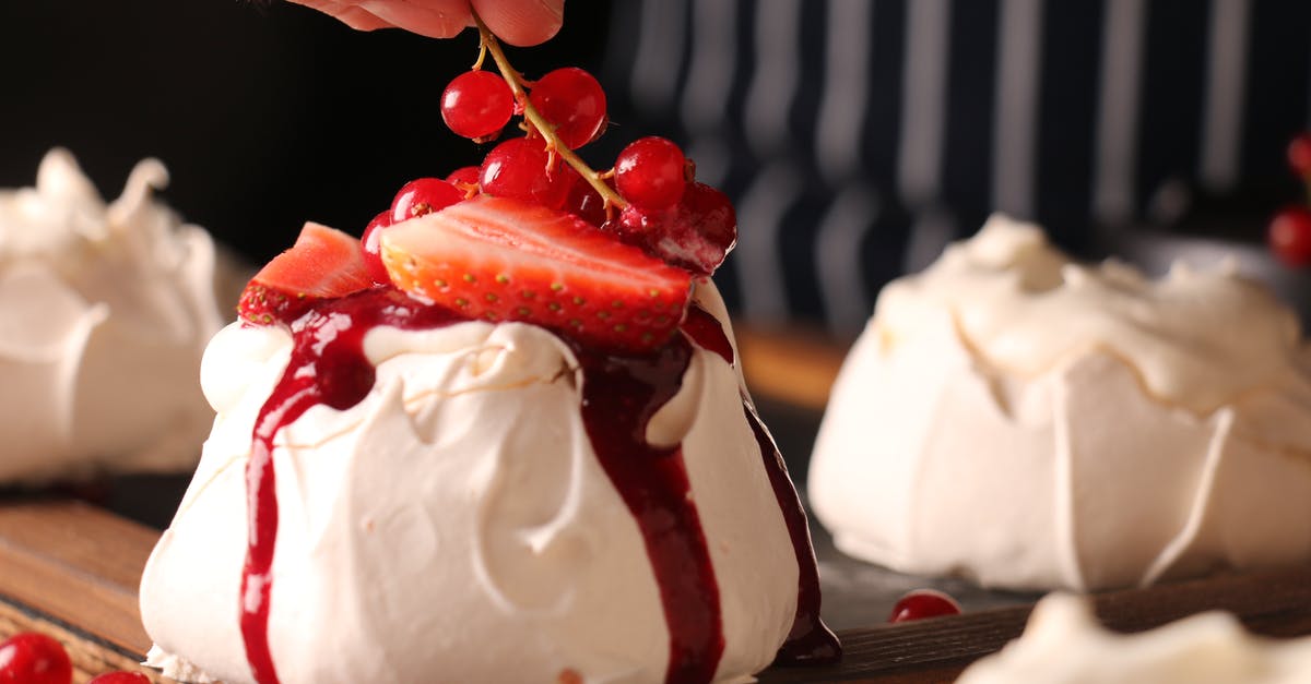 What part or kind of geoduck gives crunchy slender slices? - Crop anonymous cook decorating tasty crunchy meringue cake with ripe strawberry slices and sprig of colorful red currants on top of sweet red sauce in restaurant kitchen