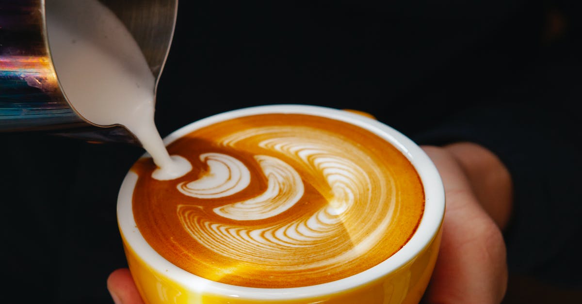 What plant-based (non-dairy) milk do not separate when making caffe latte? - Crop barista pouring milk into coffee with foam in cafe