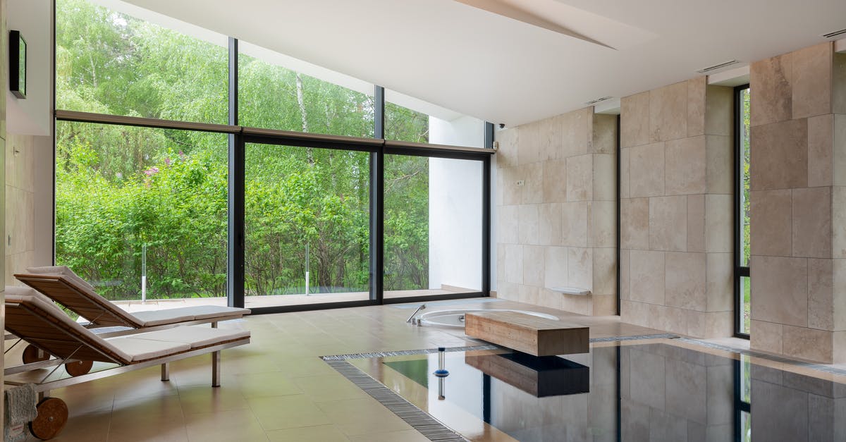 What property makes a liquid soapy/bubbly? - Interior of contemporary large apartment with deck chairs and swimming pool with clean water in daytime