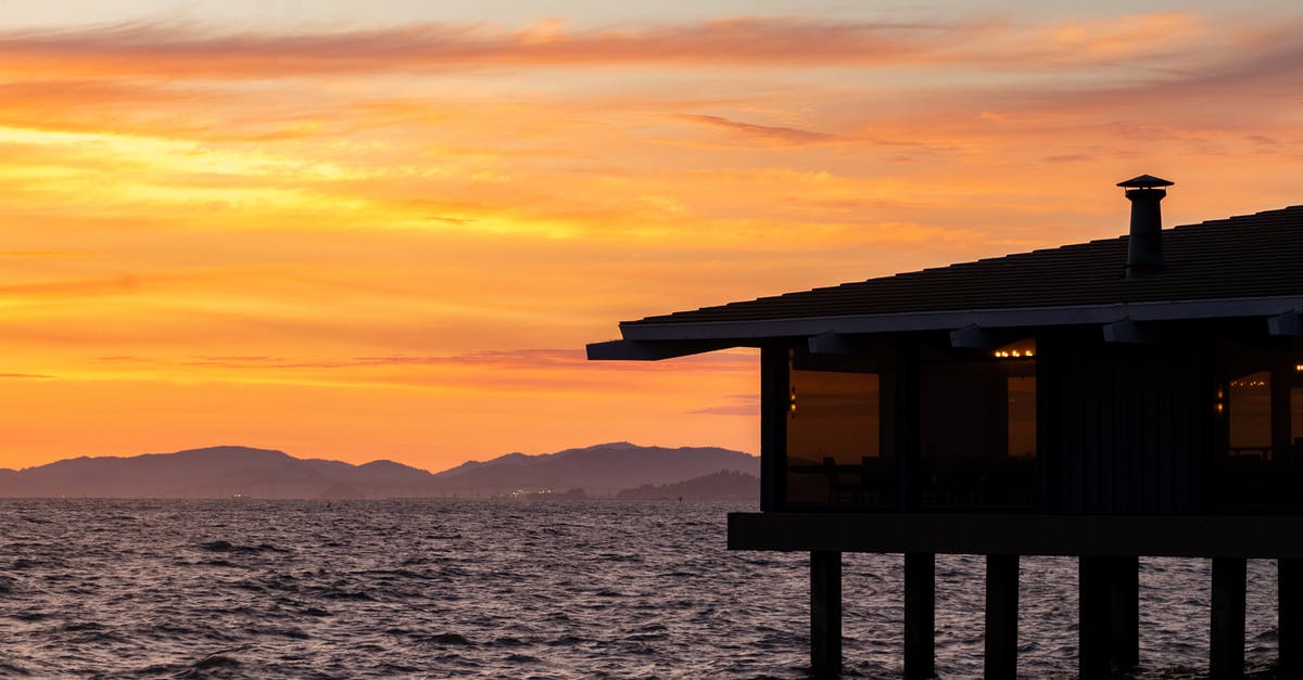 What property makes a liquid soapy/bubbly? - Building on stilts on rippling river near silhouette of rough mountains on picturesque golden sunset