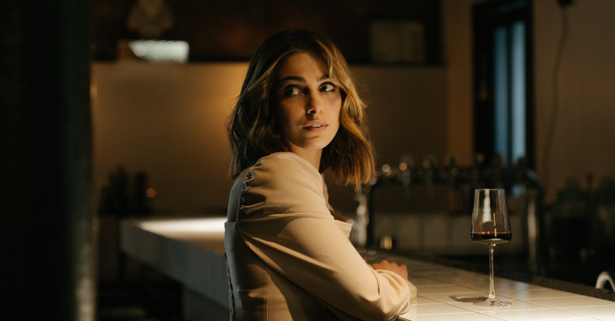 What red wine goes with fish? - Woman in Gray Long Sleeve Shirt Sitting on Bar Seat