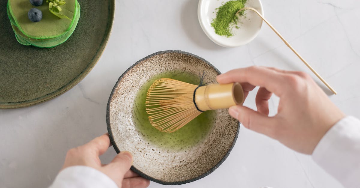 What should I do if I forgot to dry fries before baking? - Top view of anonymous cook mixing green food coloring with water using whisk on white table with pancakes