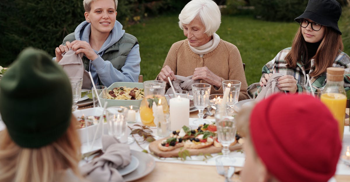 What side dish should I have with saltimbocca? - Cheerful family enjoying dinner party together in countryside