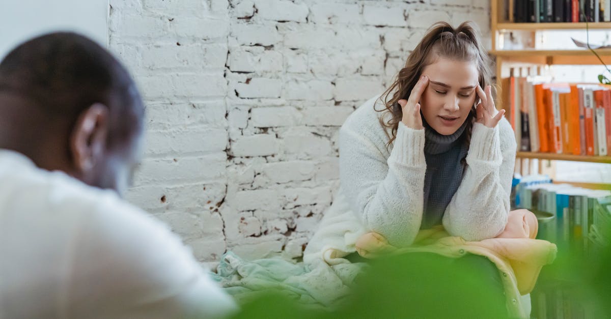 What situations are pressure cookers not appropriate - Exhausted woman calming down after argument with husband by putting fingers on temples and man sitting and looking down