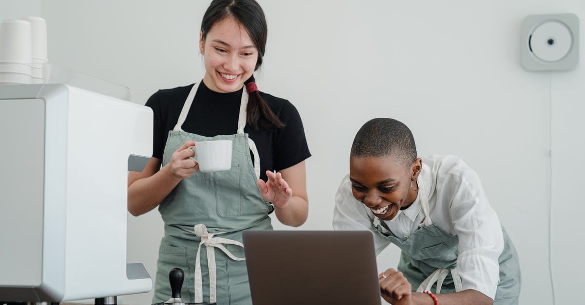 What special knowledge or skills about coffee do baristas have? - Cheerful multiracial female baristas using modern laptop during coffee break