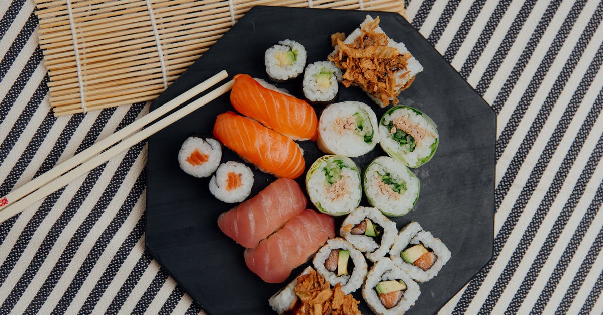 What sushi-like dish consists of various fish in a light sauce? - Plate with sushi rolls near chopsticks