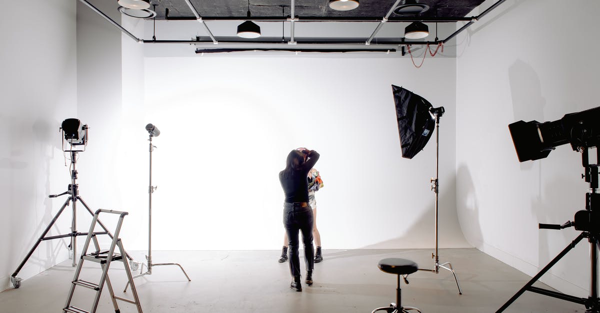 What tempering process do you use when moulding chocolates - Back view of unrecognizable professional photographer taking photo of anonymous model in modern light studio