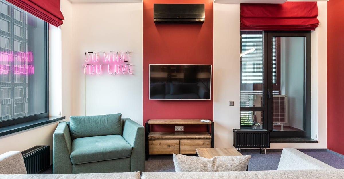 What to do with crumbled muffins? - Interior of modern office lounge zone with sofa and armchair with table near window next to TV on wall and neon signboard with text do what you love near door