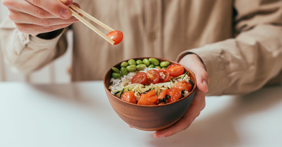 What vegetable for sauteed zucchini could I use instead of tomatoes? - Person Holding a Vegetable Rice Bowl
