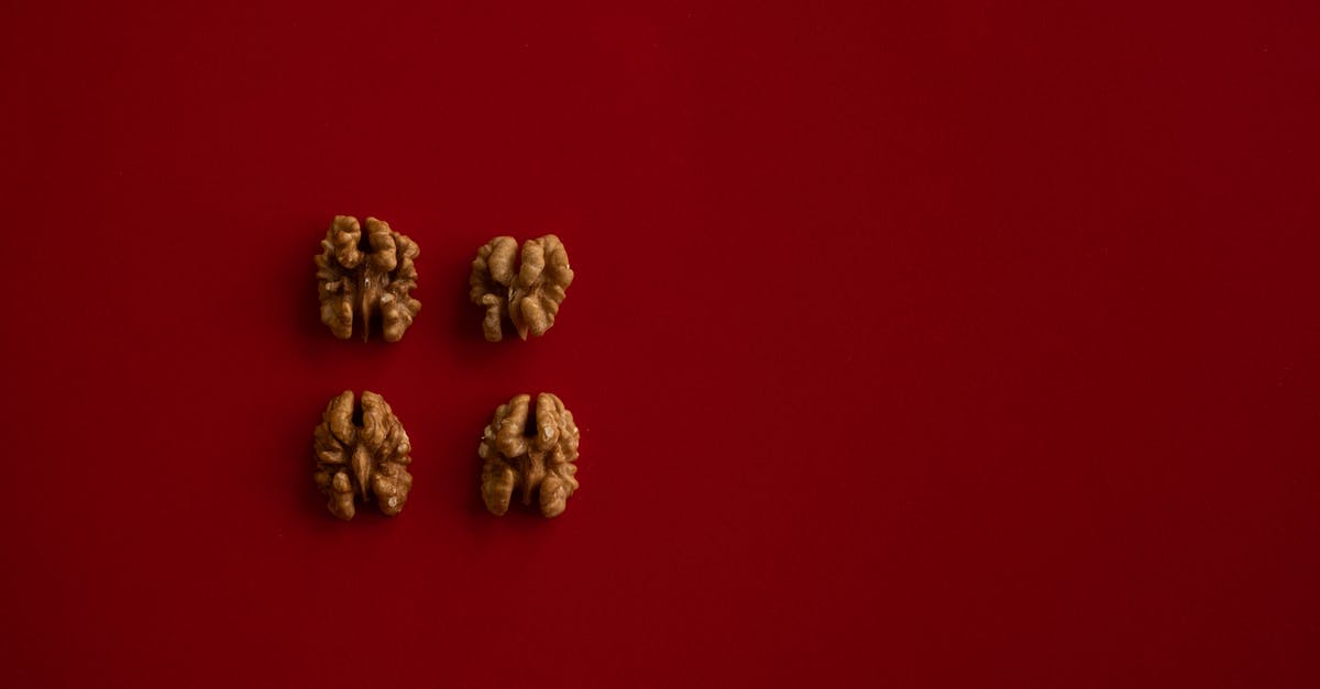 What went wrong with my walnut brittle - Top view of halves of walnut kernel regularly placed on dark red background