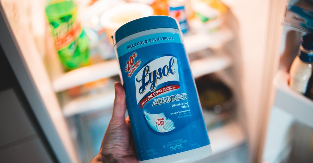 What would happen with food stored in a sterile environment? - High angle of crop faceless person holding container of antibacterial wipes near opened fridge during housework