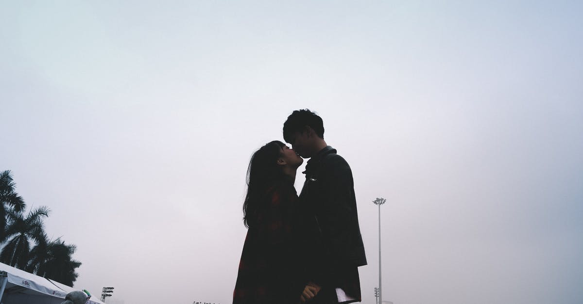 Whatever Has Happened to This Fork? - Couple Kissing Together Standing Near People