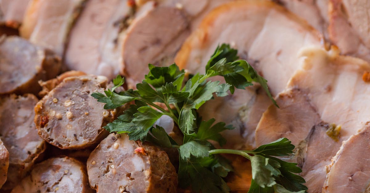 When cooking steak should the fat inside be cooked? - From above of tasty sliced sausage and meat placed on plate in daytime