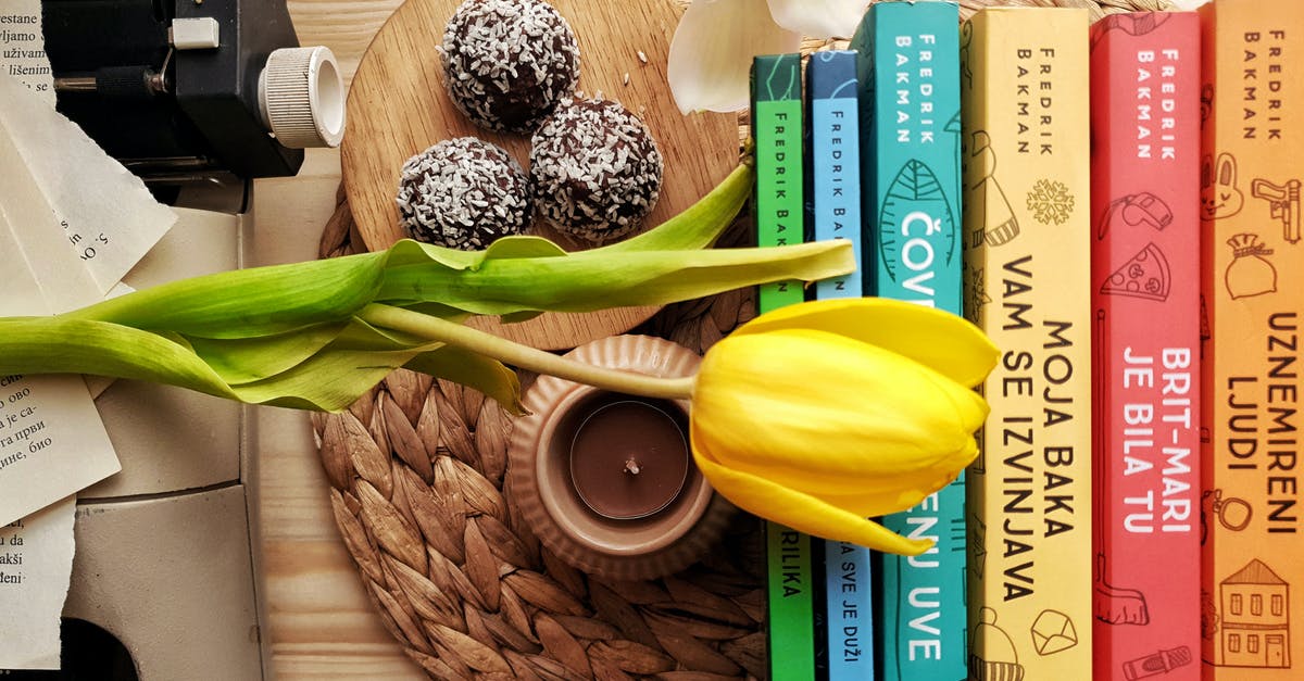 When getting coconut milk out of a coconut what type of drill bit should I use? - Top view stack of books on table near beautiful yellow tulip and orchid flowers arranged with chocolate truffles placed on wicker placemat