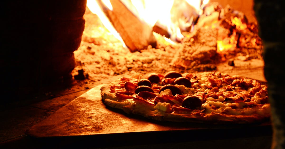 When heating up a pizza, edges burn while middle still liquid - Close-up Photo of Pizza Near Bonfire