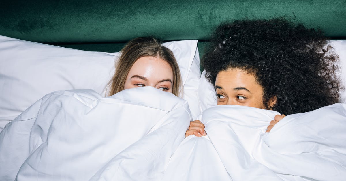 When is the best time to freeze bread? - Two Young Women Lying on White Bed While Looking at Each Other