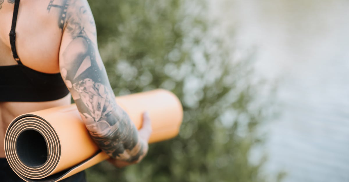 When making yogurt, why doesn't bad bacteria grow as well? - Back view of crop anonymous female in sportswear with tattoo representing film standing against pond and tree in summer