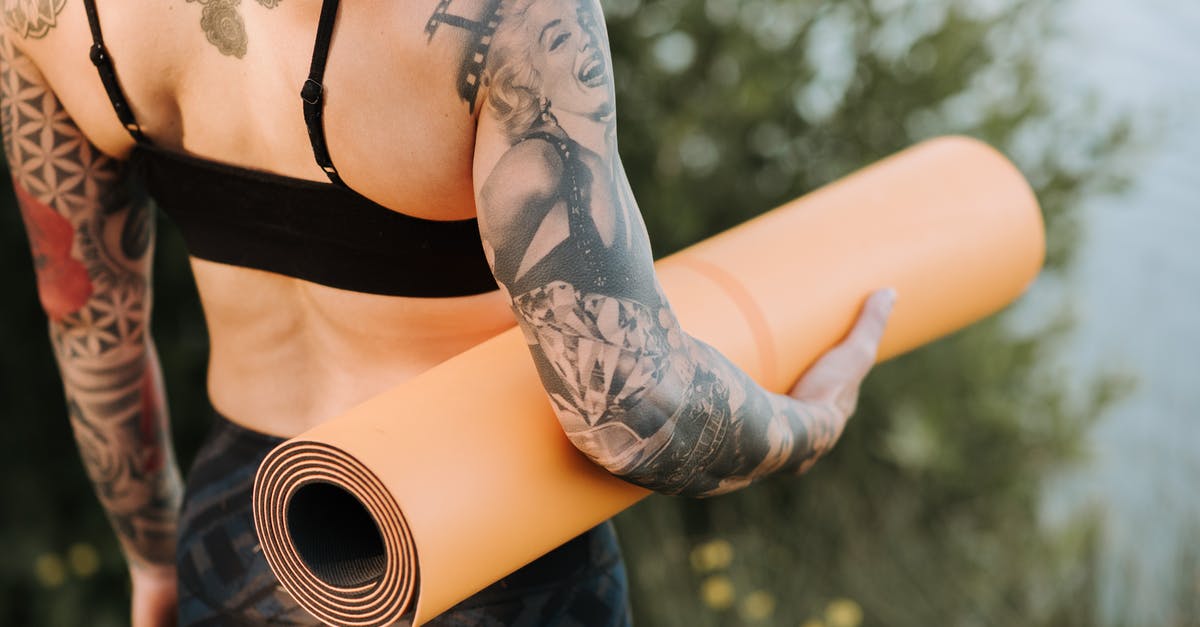 When making yogurt, why doesn't bad bacteria grow as well? - Back view of crop anonymous slender female with tattoos and rolled yoga mat standing against pond and shrub