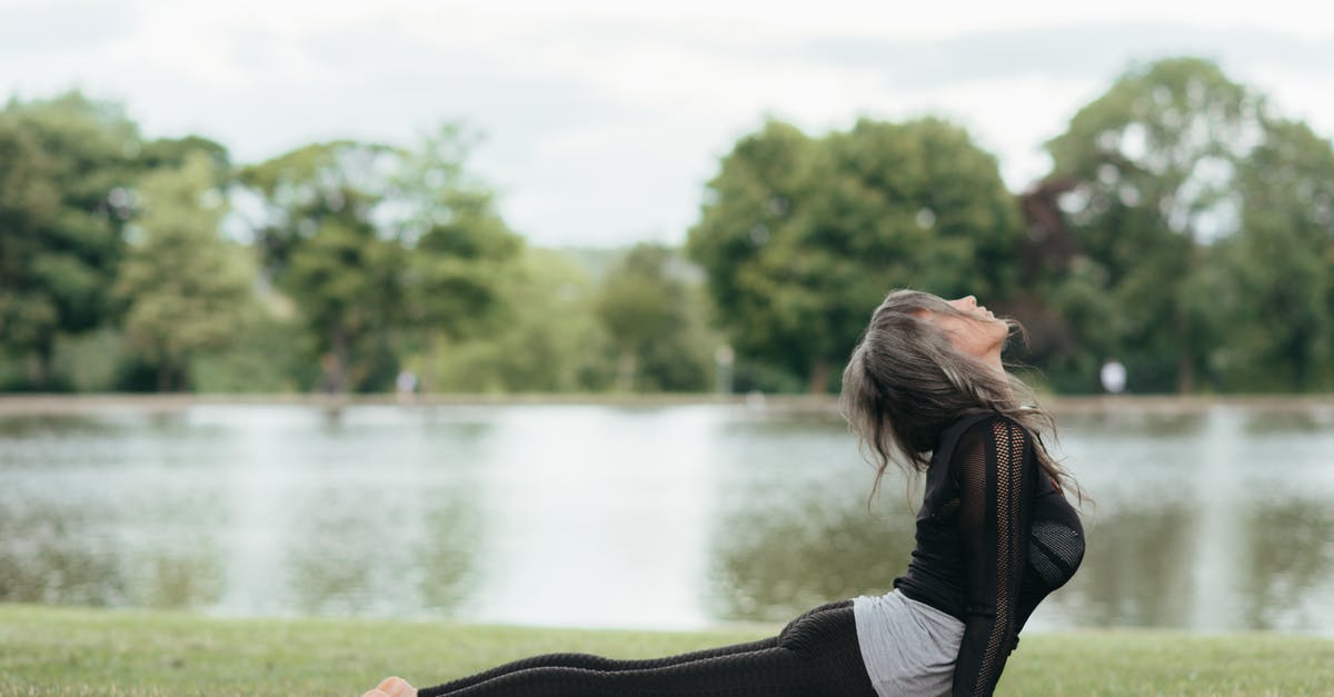 When making yogurt, why doesn't bad bacteria grow as well? - Side view of anonymous barefoot female in sportswear demonstrating High Cobra pose on grass coast against river