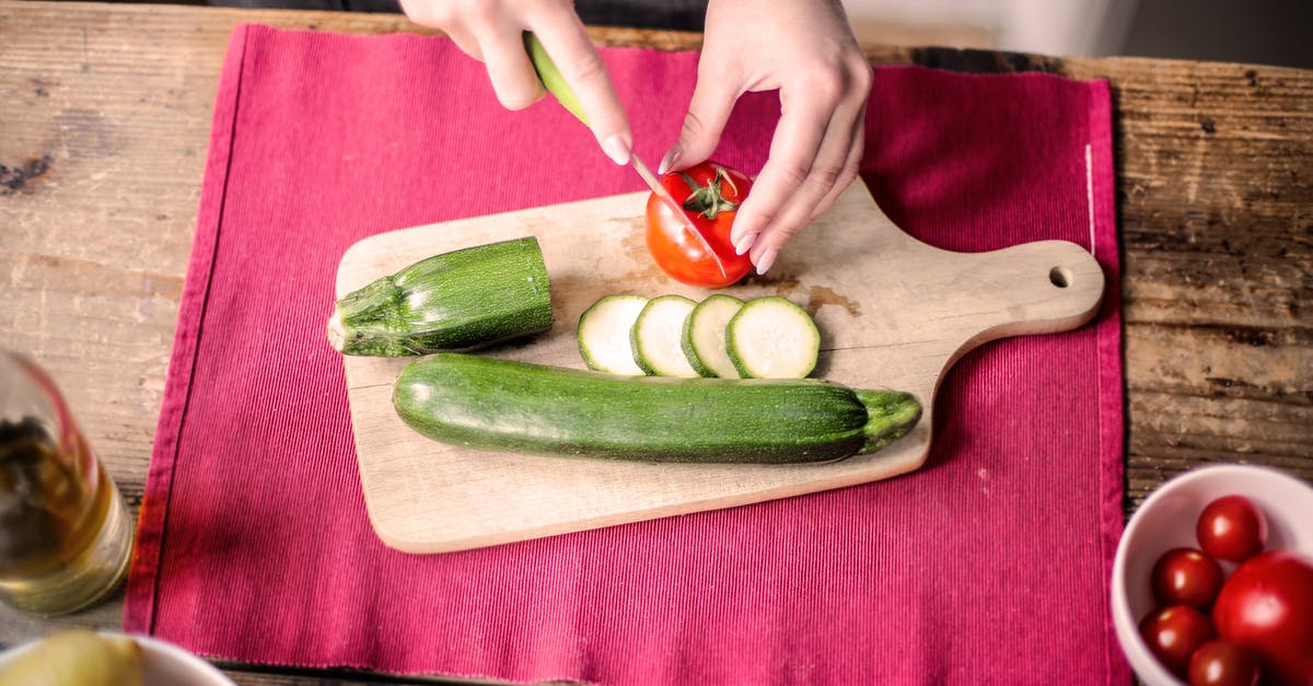 When should cutting boards be replaced? - Person Slicing Tomato on Chopping Board