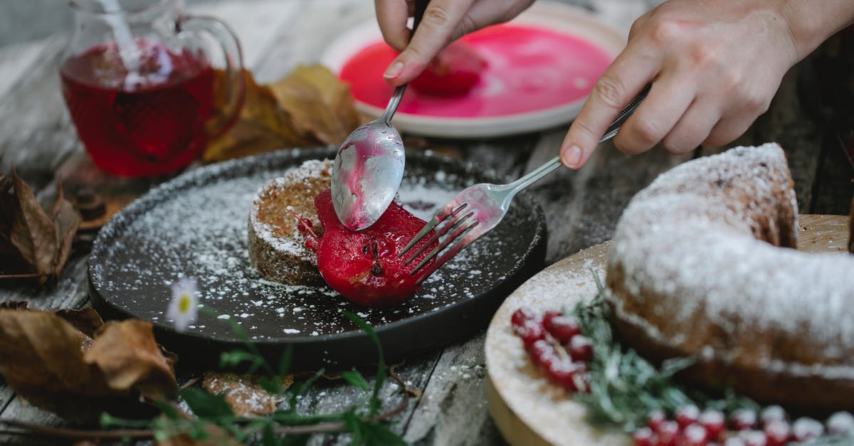 When should I add fresh fruits in homemade yogurt? - Crop faceless housewife garnishing cake with baked pear