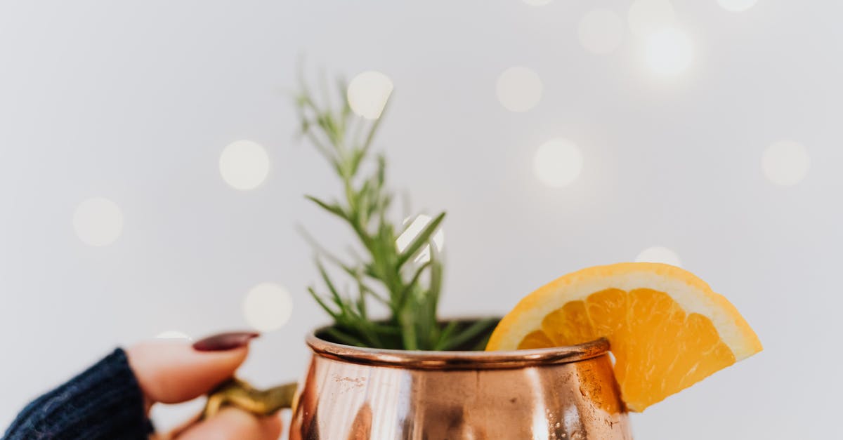 When to season popcorn? - Person Holding Clear Glass Mug With Orange Juice