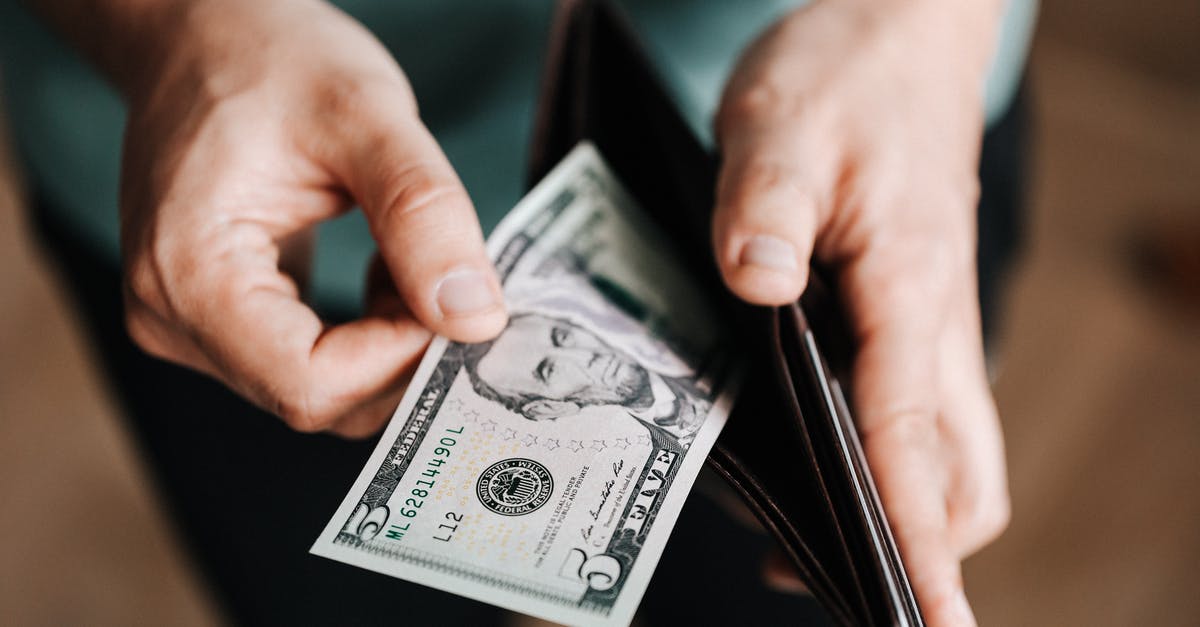 Where can I buy Prime Beef? [closed] - Unrecognizable man holding wallet with money