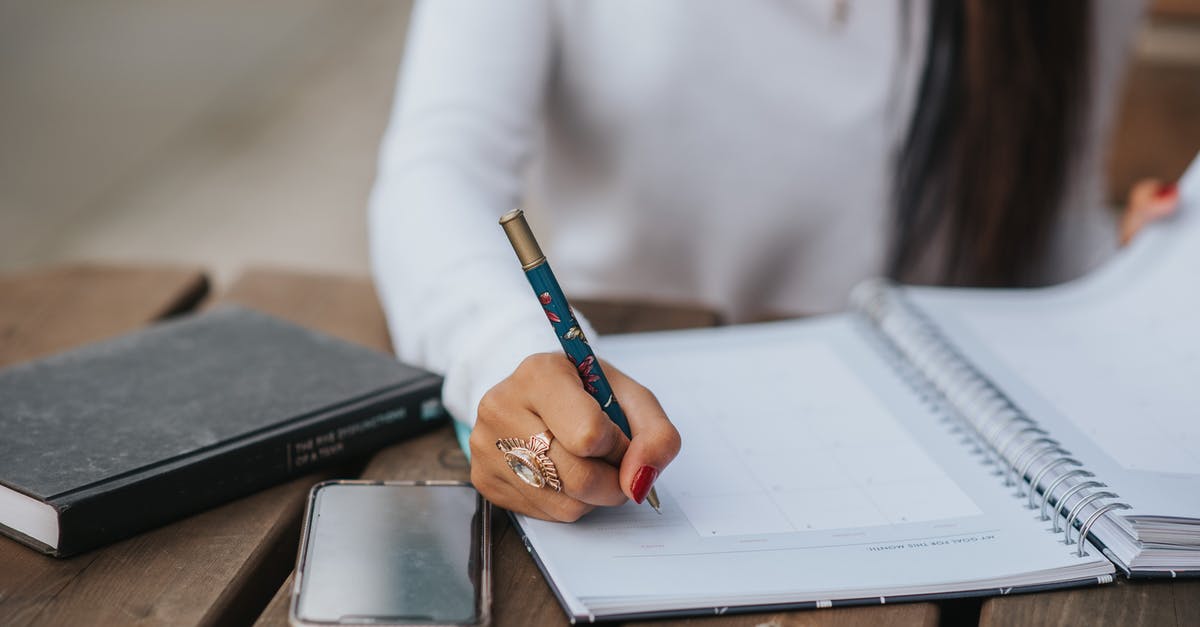 Where can I find an extremely slim wooden stirring spoon? - Crop office employee taking notes in notebook at table