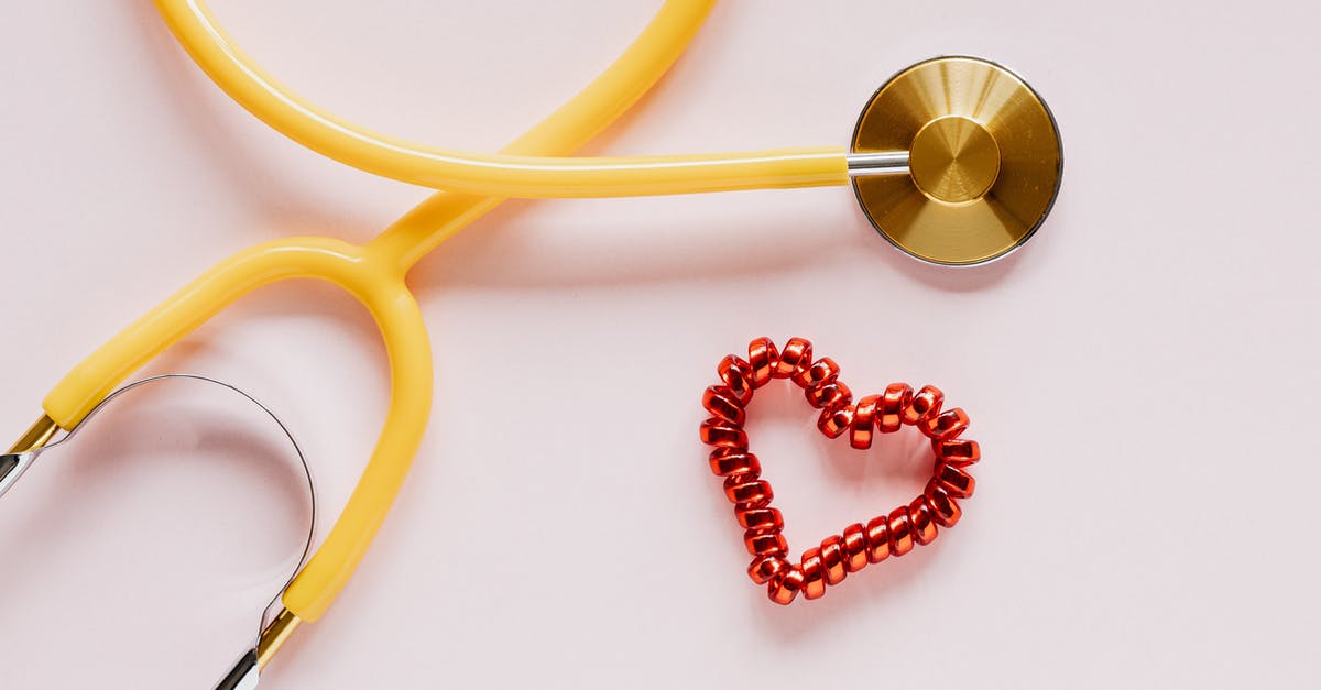 Where did the thin, smooth plastic spatulas go? - Stethoscope near decorative coil tie in heart shape on pink surface