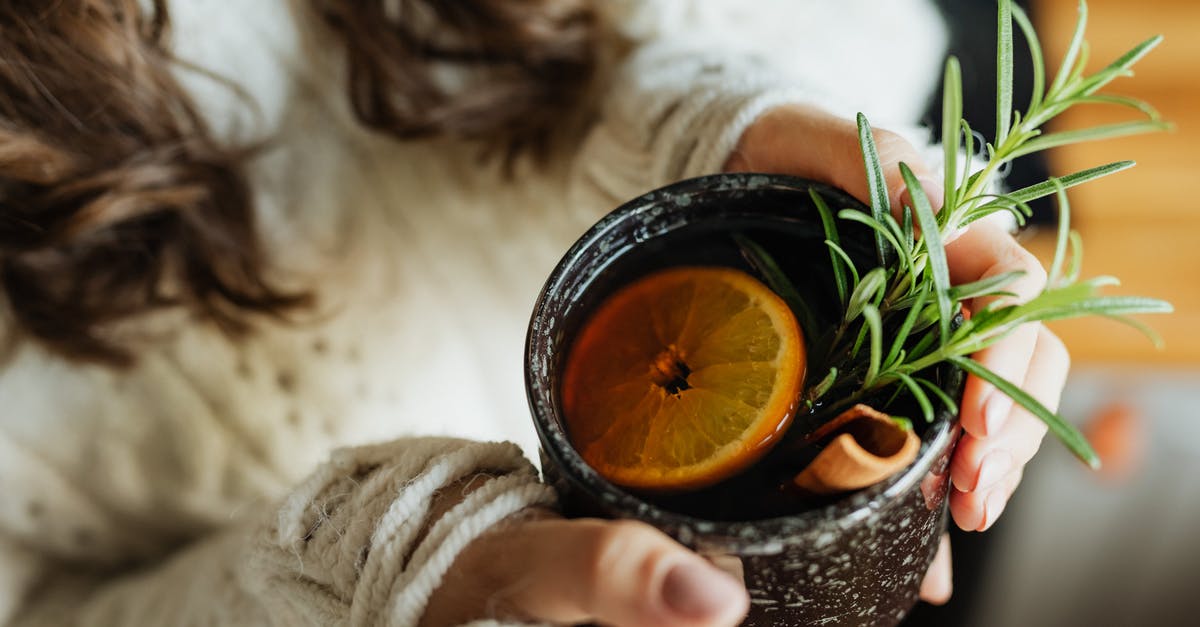 Which caffeine-free tea herbs have tannins? - Person Holding Black and Orange Round Container