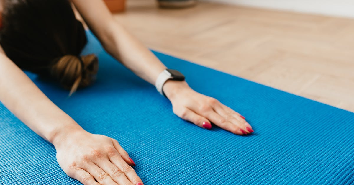 Which cooking device allows flexible temperature programming? - Crop anonymous woman practicing yoga on mat at home