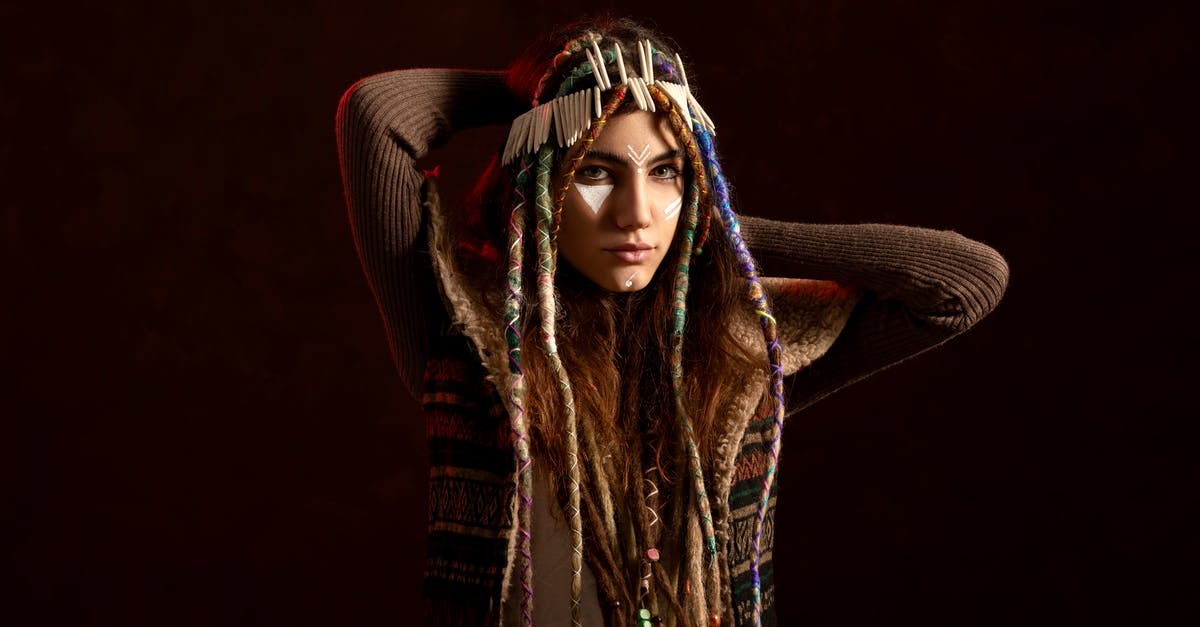 Which spice gives brown colour to Indian curry? - Young ethnic woman with threads on dreadlocks and hands behind head looking at camera on black background