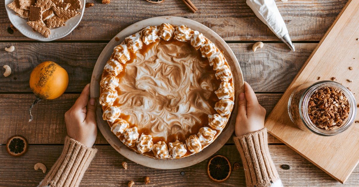Whipping cream that has been frozen won't whip - Top view crop anonymous female in sweater serving freshly baked yummy pie with whipped cream on wooden table