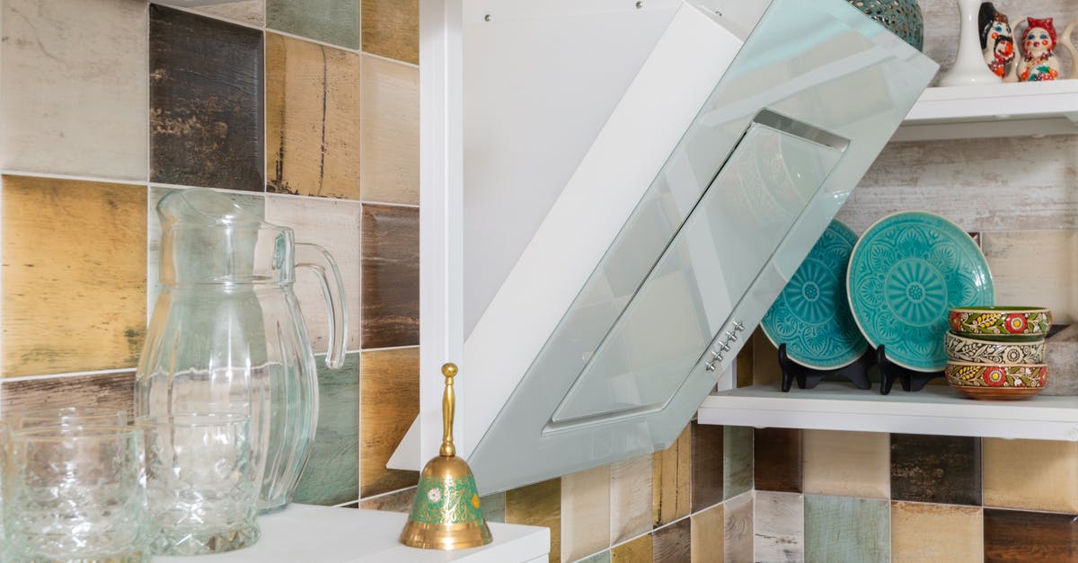 White residue after putting bacon grease laden cookware in dishwasher - Interior of light kitchen furnished with shelves with various dishware and glass bottles in modern apartment