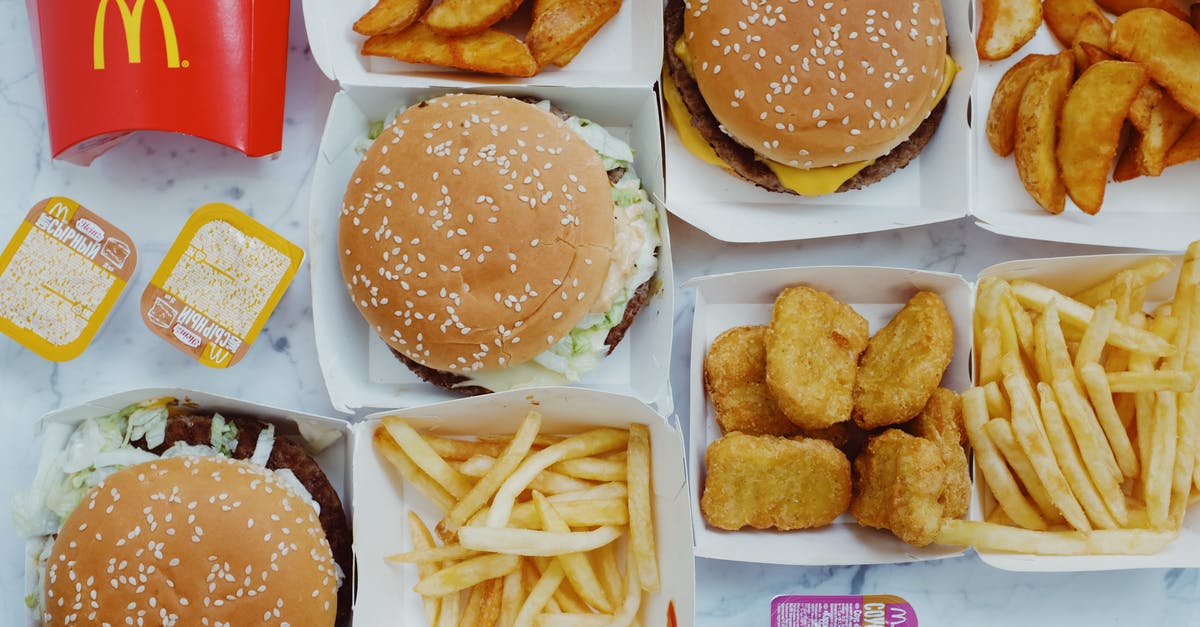 White sauce with a deliberate raw-flour taste - Top view flat lay of junk food including burgers with french fries and nuggets placed on marble table