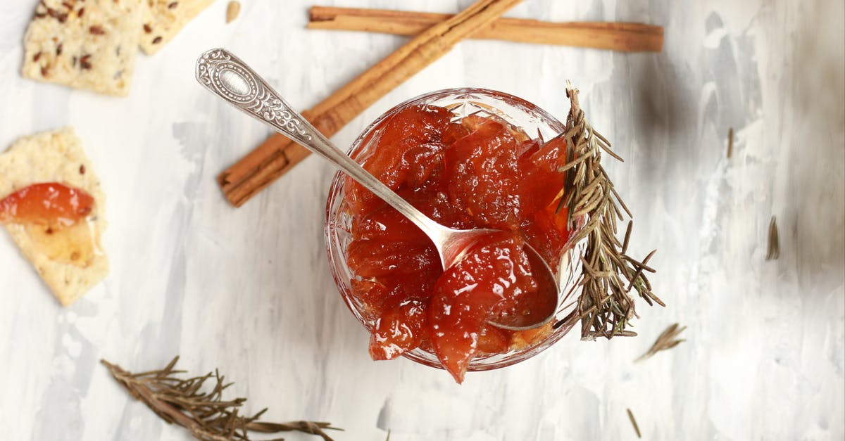 why a citric fruit rind is cooked several times to make a marmalade - Top view composition of bowl with delicious jam in cup with rosemary sprigs and crispbread with cinnamon sticks