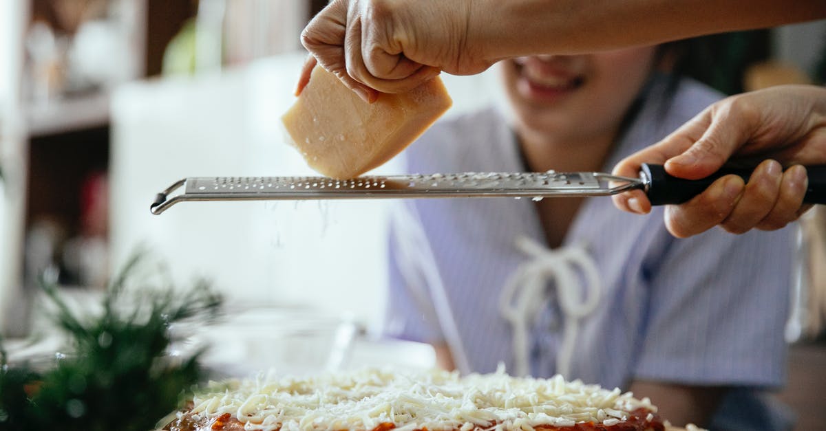 Why add a sunny-side up egg? [closed] - Woman grating cheese on pizza