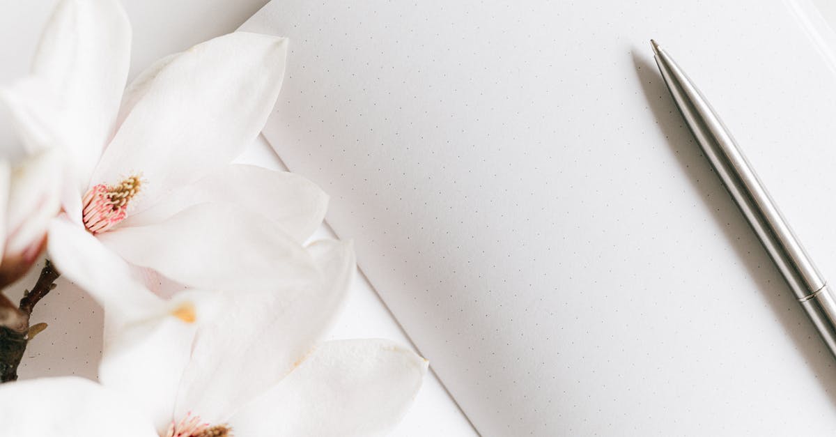 Why am i unable to season my pure iron wok? - Top view composition of opened notebook with blank white sheets arranged with silver pen and lush blooming white Magnolia flower on white table