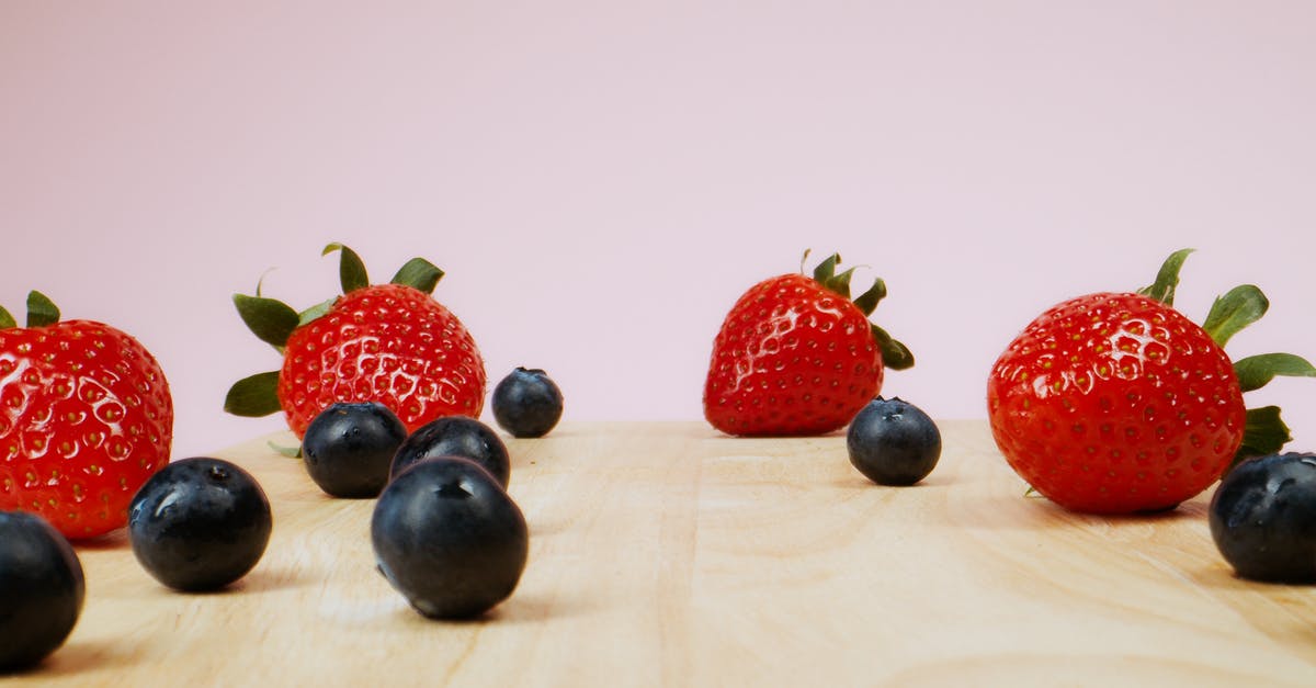 Why are berries so expensive? - Strawberries and Blueberries on a Wooden Surface 