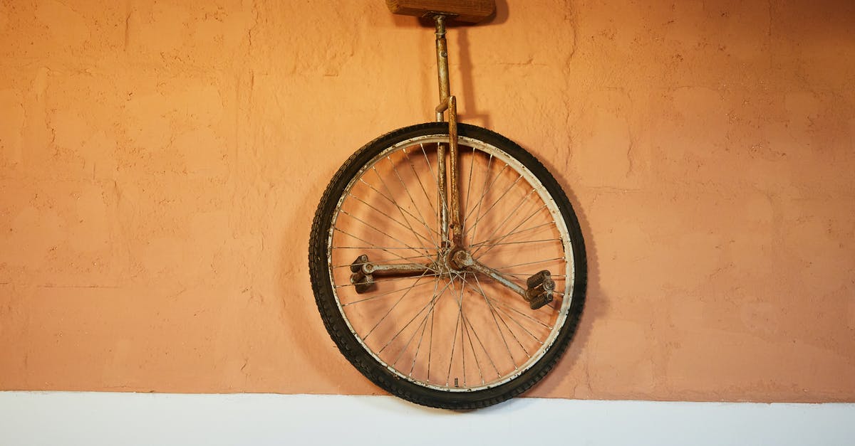 Why are brick ovens used to make pizza? - Old shabby unicycle hanging on brick wall