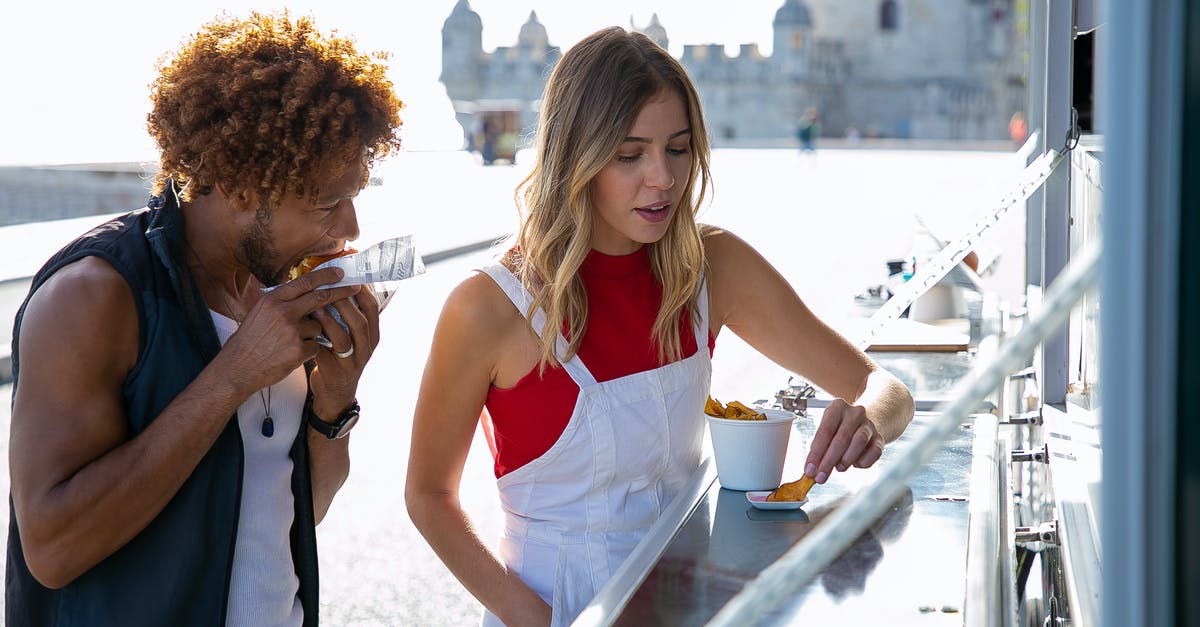 Why are my commercial fries going soggy almost immediately? - Woman eating fried potato with sauce standing near black boyfriend biting tasty burger at food truck