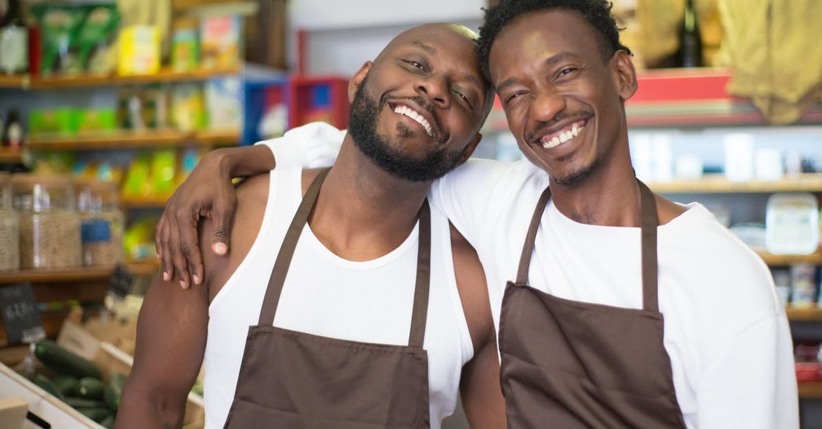 Why are vegetables often left unrefrigerated at the grocery store? - Men Smiling Together while in a Grocery