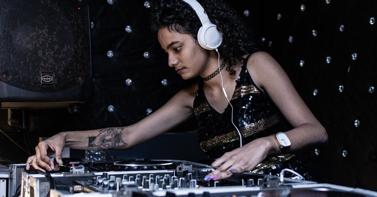 Why boil and cool jam before using it in a cake? - Focused ethnic female DJ playing music at nightclub