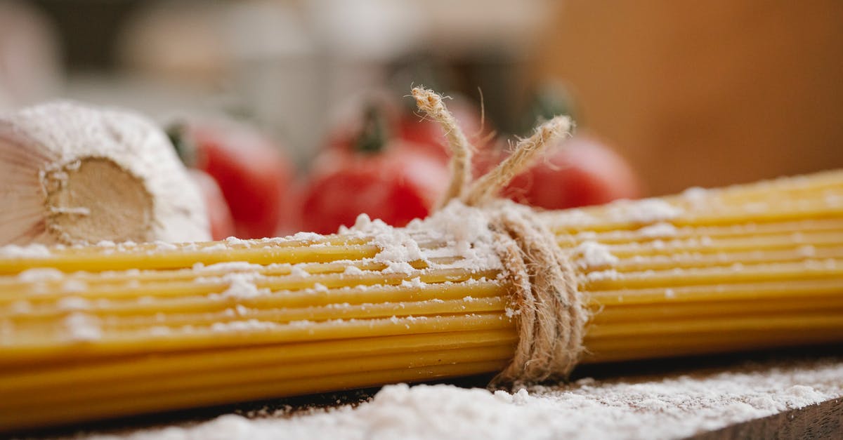 Why can you eat raw oat flour but not raw wheat flour? - Closeup of ingredients for cooking Italian dish consisting of spaghetti tomatoes and garlic with flour