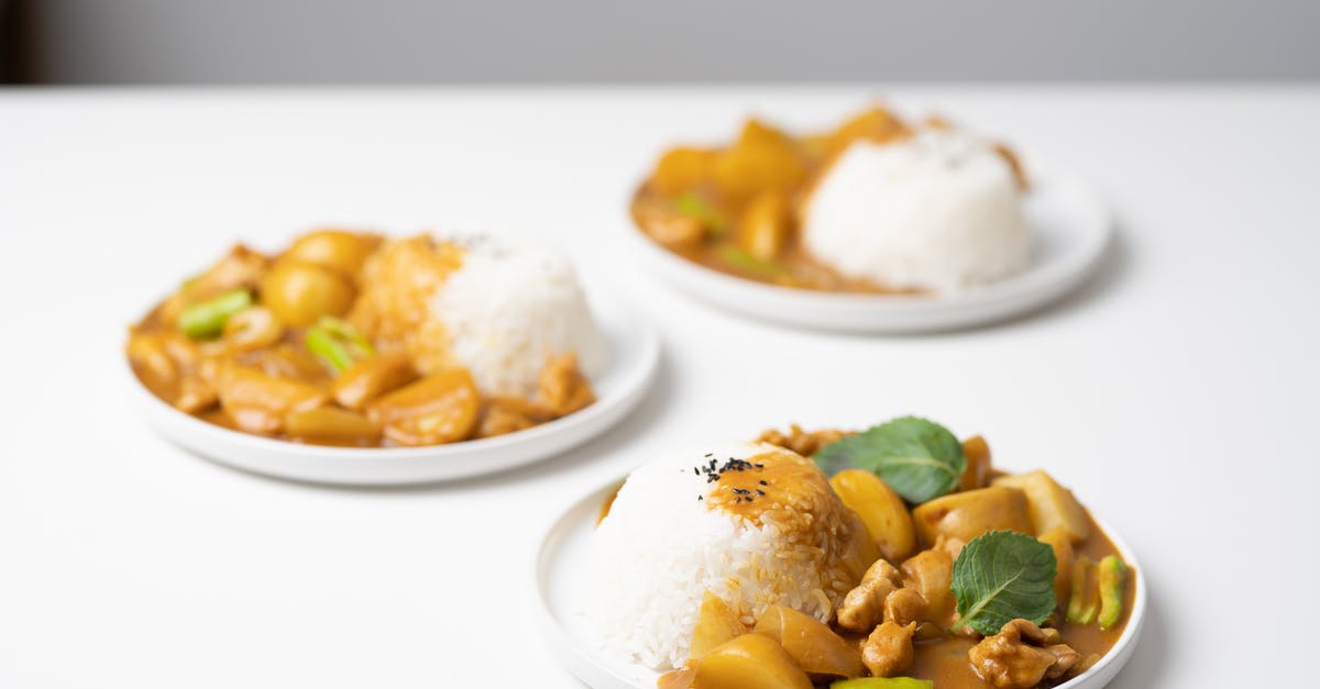 Why cook stewing meat low and slow? - From above of served white table with portions of traditional Indian dish curry on ceramic plates