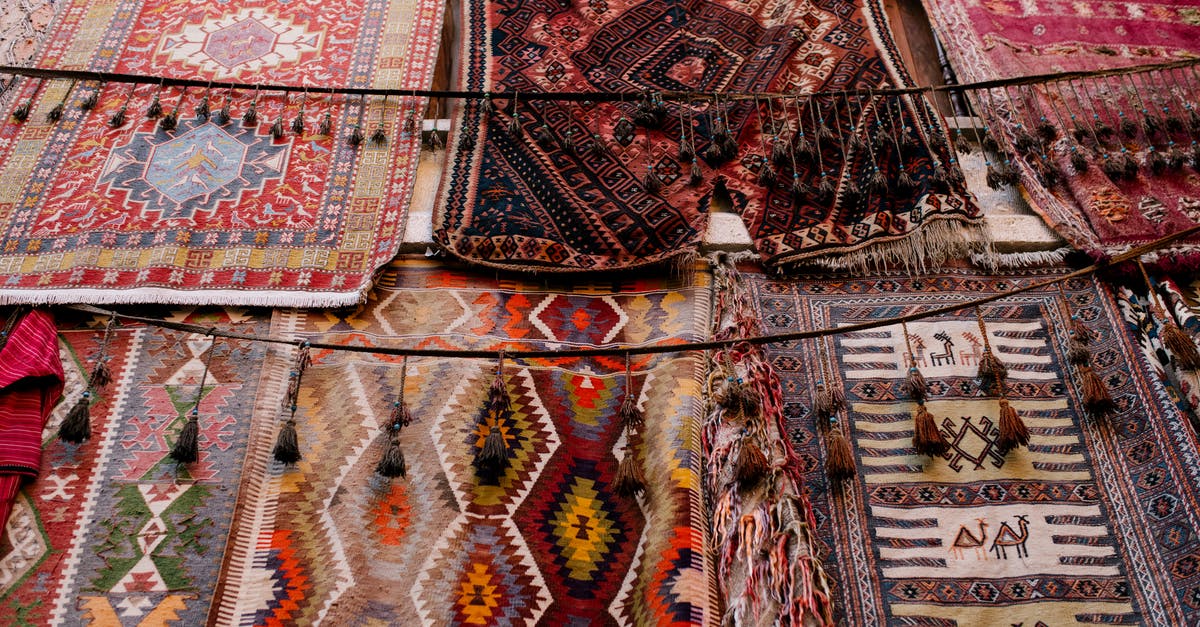 Why did flatbread dominate the Middle East but Europe adopted raised breads? - Colorful handmade weaved with oriental ornament middle east rugs hanging in open market