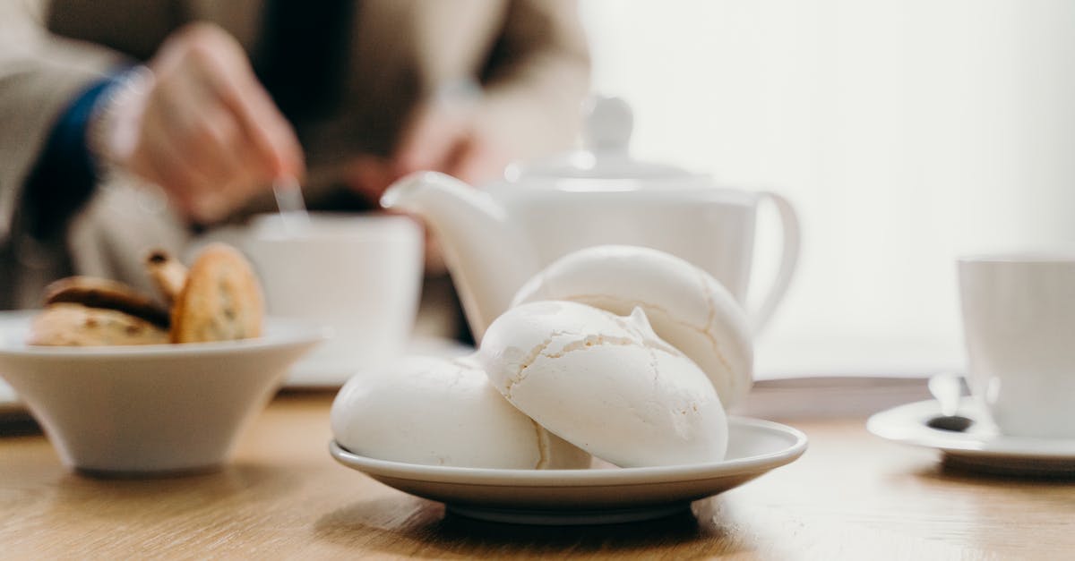 Why did my meringue deflate and go soft? - Crop anonymous businessman drinking tea with cookies in cafe