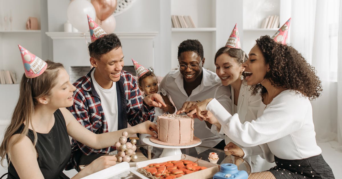 Why did my rum cake turn black? - A Group of People with Party Hats Sitting at a Table with a Birthday Cake