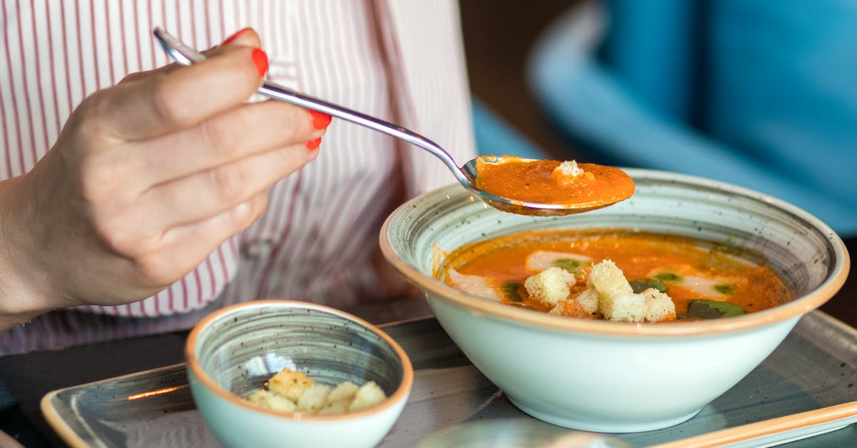 Why did my tomato soup turn thick and brownish? - Person Holding Silver Spoon and White Ceramic Bowl With Soup
